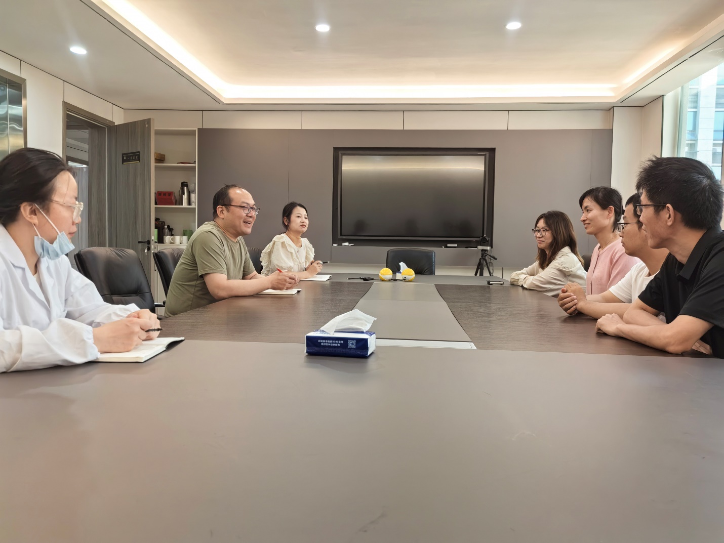 一群男人和女人在桌子边AI 生成的内容可能不正确。